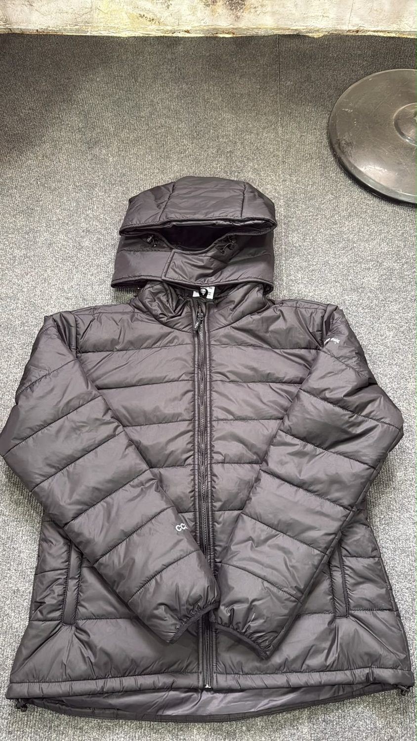 A charcoal quilted puffer jacket with the hood laid back above the collar
